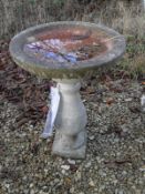 A composite stone bird bath on baluster support,