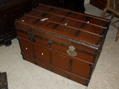 A brown painted steamer trunk with iron bindings