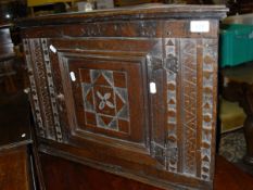 An 18th Century style oak wall-hanging corner cupboard with single carved door