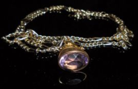 A gold and pink gold mounted oval cut amethyst pendant seal on a gold coloured chain