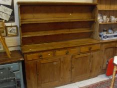 A 19th Century and later pine dresser with moulded cornice above three shelves on a base of three