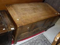 An early 20th Century oak mule chest, the plain top above panelled front, above two drawers to base,