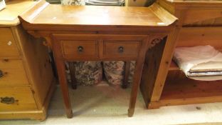 A Chinese style pine side table with two drawers,