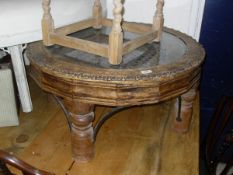 An Eastern hard wood circular coffee table with glass top with decorative latticed work iron under