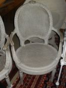 A two seat sofa and two armchairs with caned backs and seats in the French taste, painted cream,