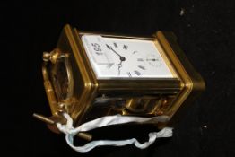 A brass and glass carriage clock with Roman numerals to the enamelled dial with subsidiary hours