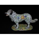 A late 19th/early 20th Century French faience figure of a stylised Pyrenean Mountain Dog with all