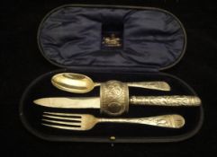 A George V cased silver Christening set comprising knife, fork, spoon and napkin ring,
