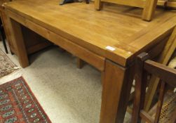 A modern oak rectangular dining table raised on square legs,