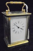 A circa 1900 French lacquered brass cased carriage clock with visible escapement,