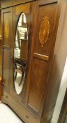 An Edwardian mahogany single mirror door wardrobe with drawer below and a 1920's mahogany bow