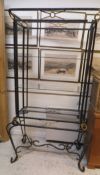 A modern painted metal framed three tier glass shelved unit