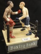 A reproduction cast iron boxing money bank depicting two boxers in a boxing ring,