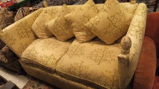 A Knoll style sofa with yellow upholstery with green tree decoration