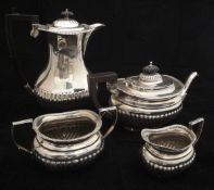 An Edwardian silver three piece tea set of rectangular bellied form with reeded base,