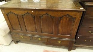 A 19th century provincial oak mule chest the rising top over four fielded arch panels and three