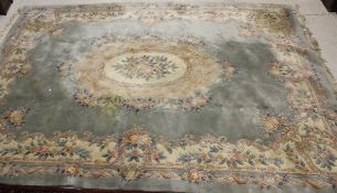 A large Chinese superwash carpet, the central panel set with floral decoration on a green ground,