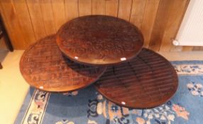 An Eastern hardwood coffee table set as three circular discs upon three levels each bearing carving