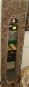 A narrow rectangular wall mirror with deep relief carved border decorated with leaves