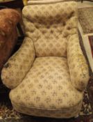 A Victorian Howard style button back armchair, raised on turned and ringed front legs,
