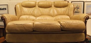 A modern cream leather upholstered three seat sofa and pair or matching arm chairs and pouffe