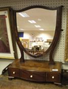 An Edwardian mahogany shield shaped toilet mirror on a serpentine fronted three drawer base with