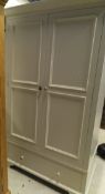 A modern painted two door wardrobe with drawer beneath and a modern Victorian style cream painted
