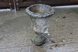 A composite stone garden urn with Classical figures and twin handles,