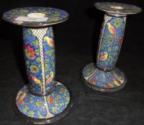 A pair of Doulton Chintz ware candlesticks decorated with parrots amongst blossoming foliage