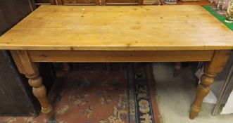 A rectangular pine kitchen table on turned supports