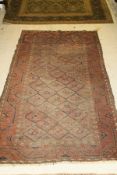 A Caucasian rug, the central panel set with lattice and diamond pattern on a pink and cream ground,