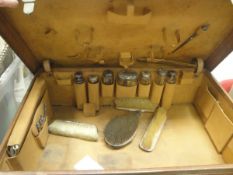 A vintage leather vanity case and contents of various silver mounted cut glass bottles, brushes,