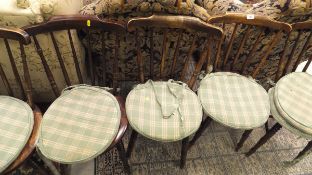 A set of six stick back kitchen chairs with circular seats,