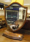 An Edwardian mahogany and satinwood strung shield-shaped dressing mirror on serpentine fronted base,