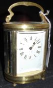 A circa 1900 French lacquered brass cased carriage clock of oval form,