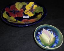 A William Moorcroft deep blue ground floral decorated bowl with flared rim and a smaller green