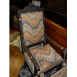 An oak framed arm chair with carved shaped top rail with raked back scrolled arm and hand rest,