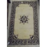 An Oriental rug, the central panel set with single flower head motif on a plain cream ground,