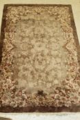 An Art Deco Chinese carpet, the central panel set with floral sprays in brown and cream,