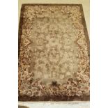 An Art Deco Chinese carpet, the central panel set with floral sprays in brown and cream,