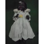 A German black porcelain headed doll with composition bent limb body,