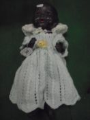 A German black porcelain headed doll with composition bent limb body,