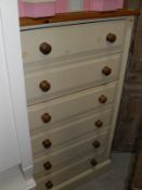 A pine topped and cream painted chest of six drawers to plinth base