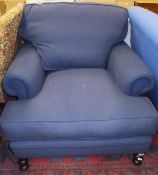 A modern upholstered armchair of large proportions in blue upholstery,