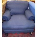 A modern upholstered armchair of large proportions in blue upholstery,