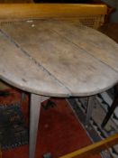 A 19th Century pine cricket table of circular planked top on base of three chamfered tapering legs