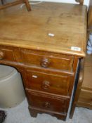 A pine topped dressing table with seven assorted drawers to bracket feet