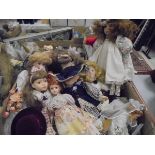 A collection of twenty period dressed porcelain dolls and a collection of thirteen various wooden