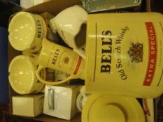 A box containing various pub ephemera including Bell's Scotch Whisky ashtrays and water jugs,