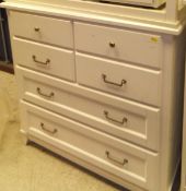 A modern white painted pine cabinet of two drawers over two cupboard doors on a plinth base,